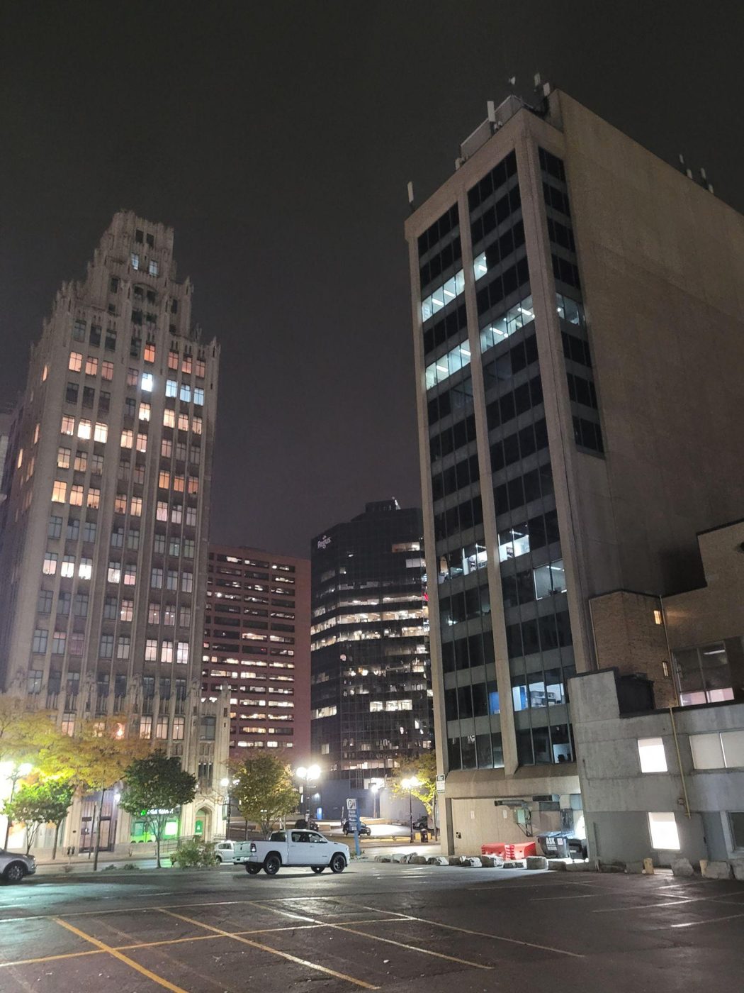 Downtown towers lit up over an empty parking lot at night